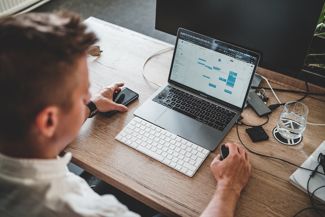 Business owner using digital software tools on laptop and phone